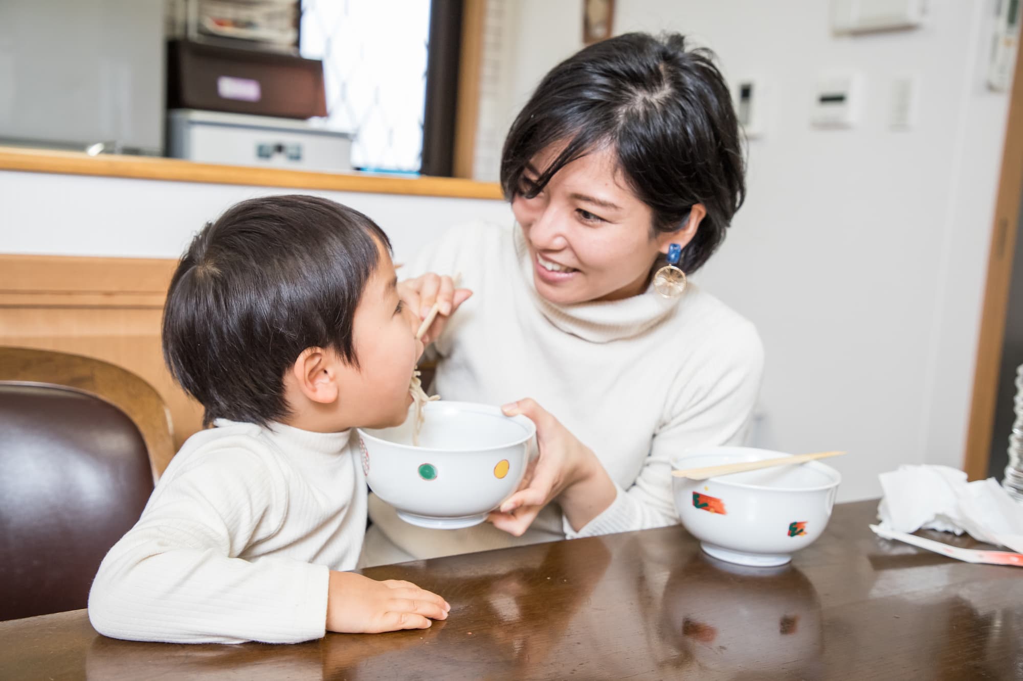 母親とうどんを食べる男の子