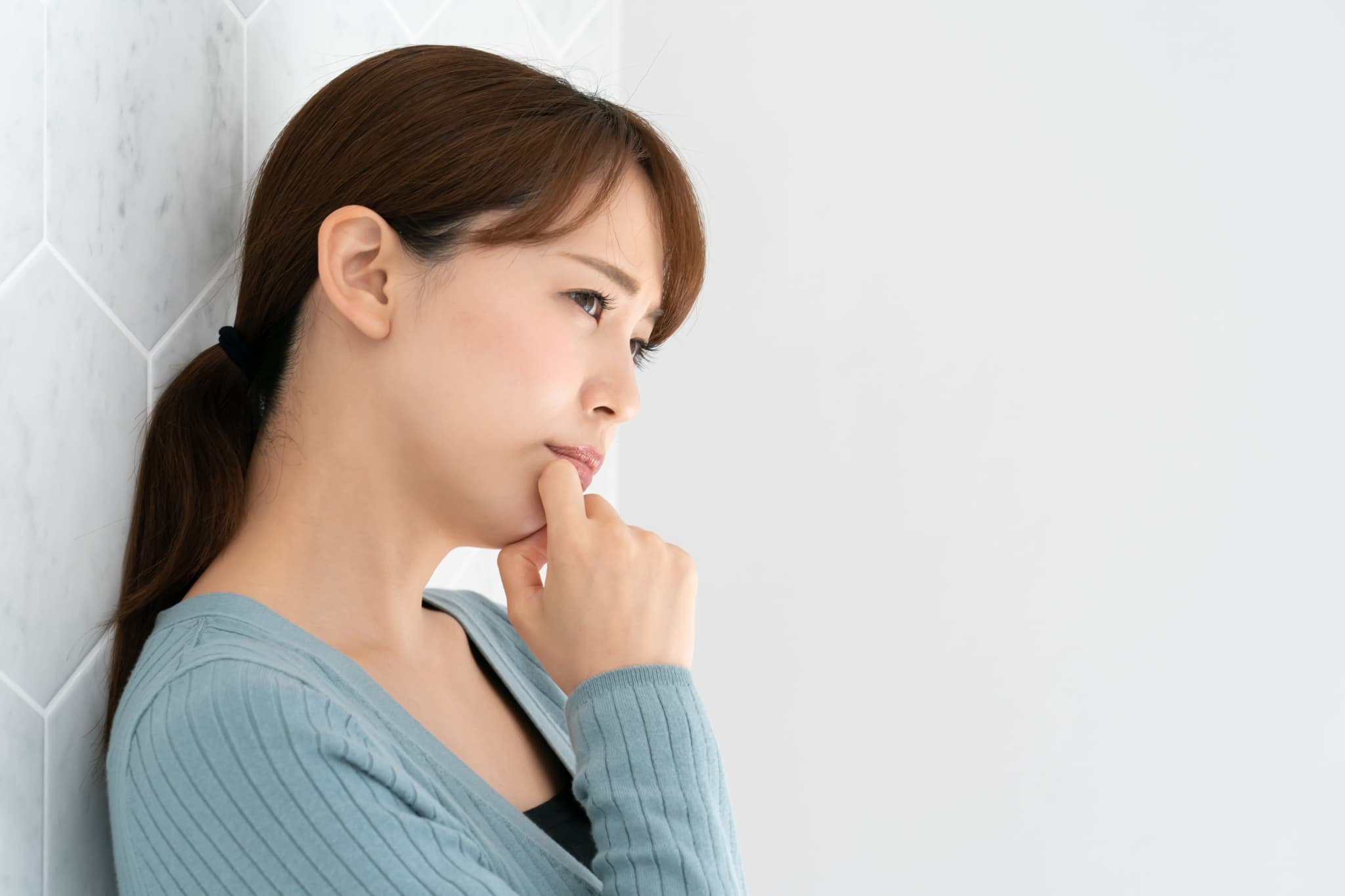 審美歯科治療に保険は適用されるのか考える女性