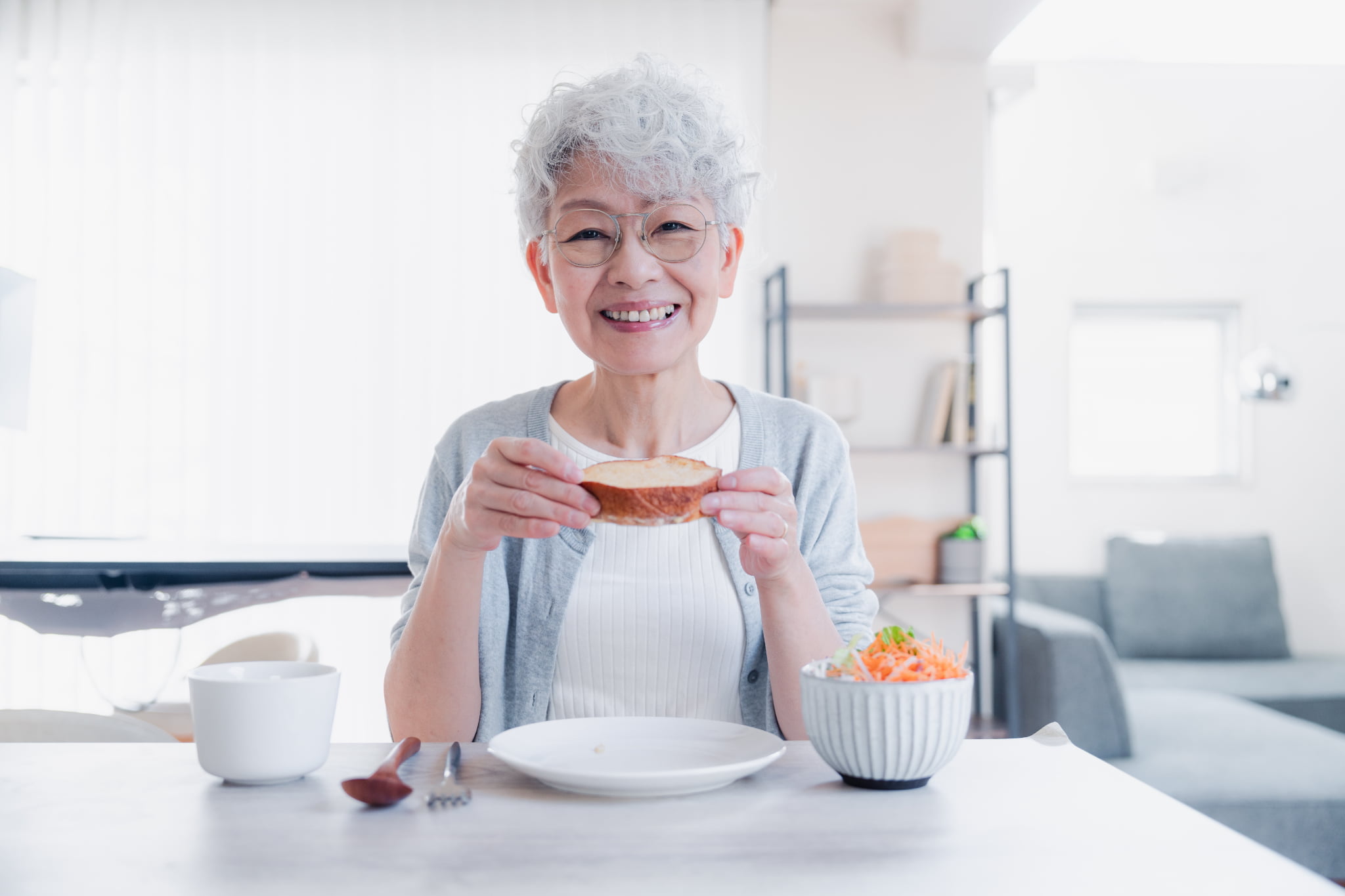 自分に合った入れ歯で快適に食事をしているシニア女性