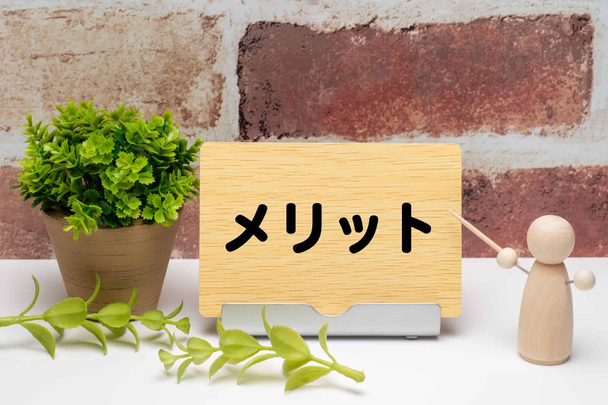 木の板に書かれたメリットの文字を棒で示す木の人形
