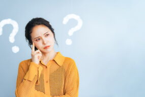 矯正治療中に痛みを感じるのはなぜか考える女性