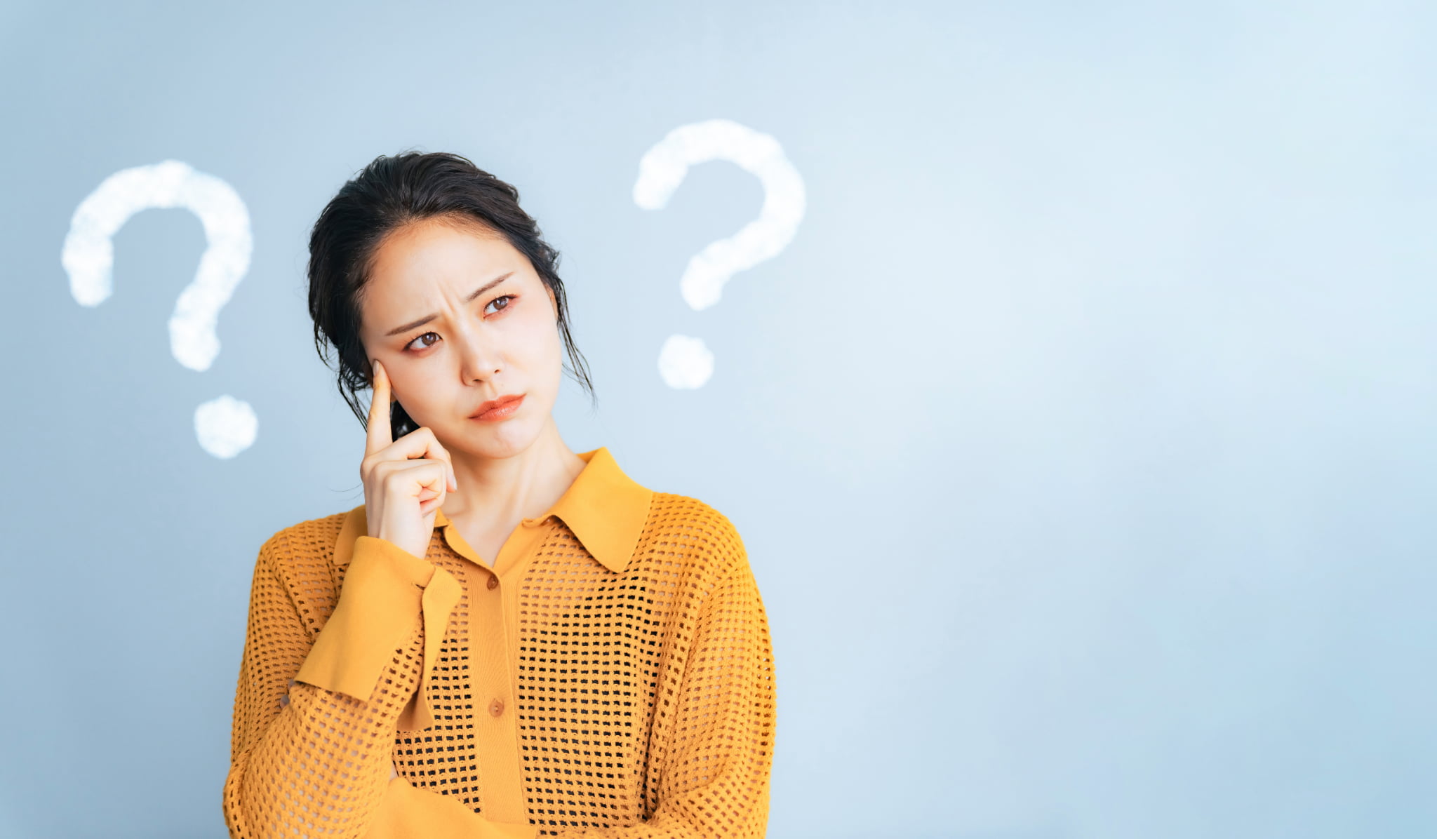 矯正治療中に痛みを感じるのはなぜか考える女性