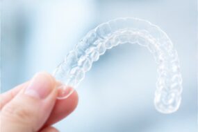 歯の矯正用のマウスピースを持つ手
